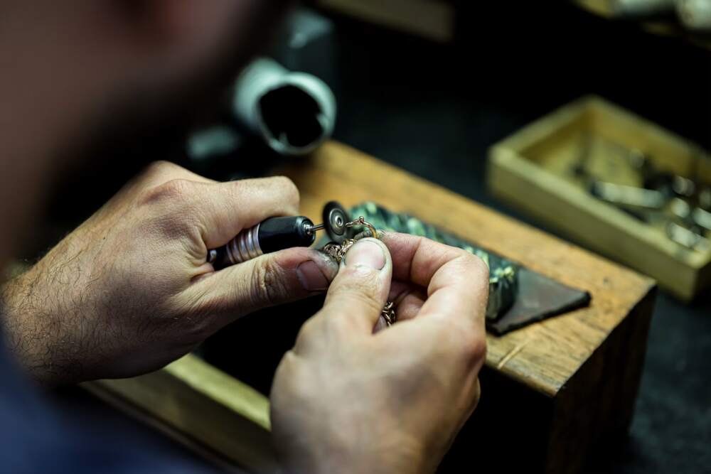 A jeweller setting a diamond into a gold ring at the bench